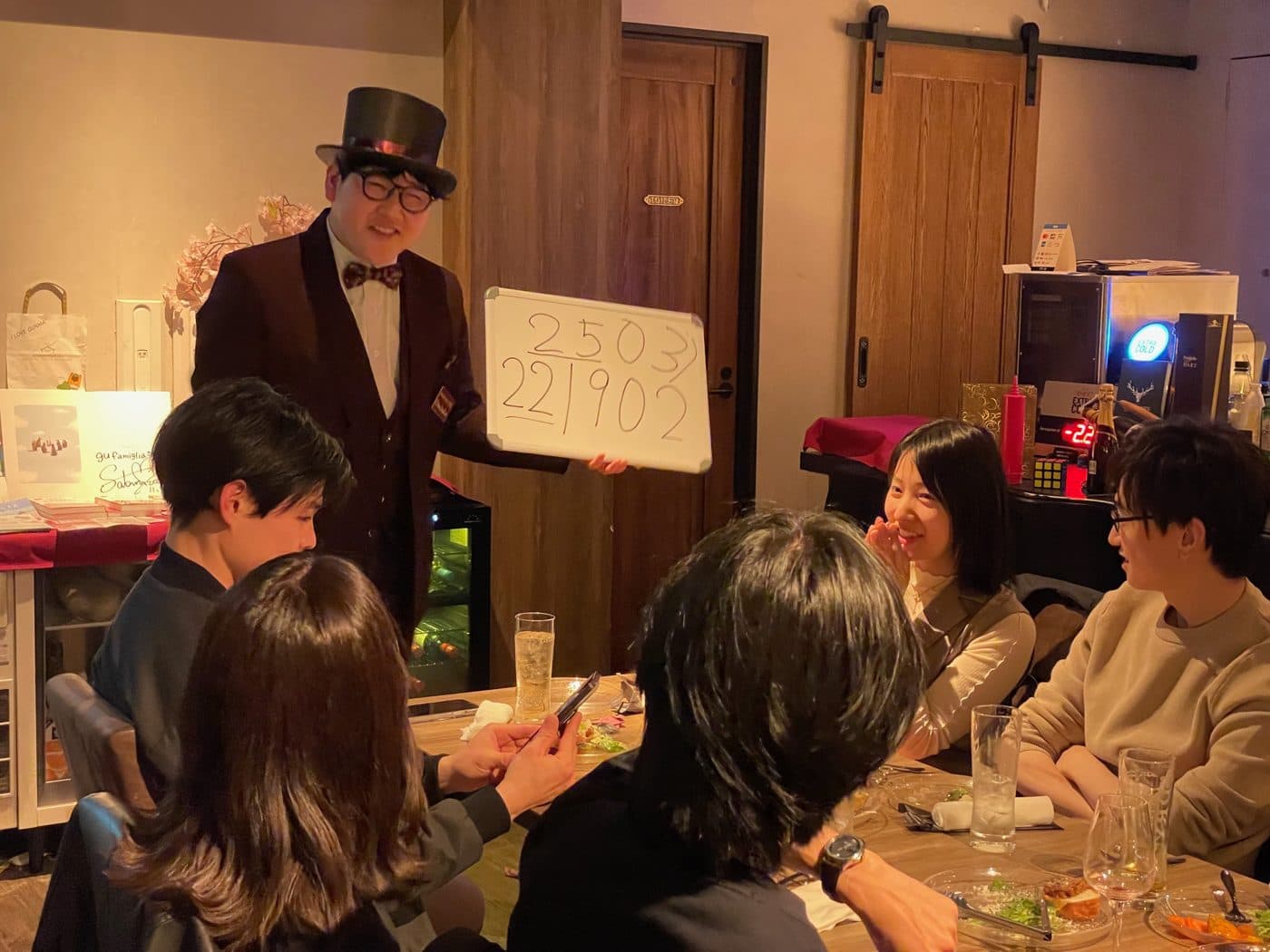 シルクハット姿で宴席のゲストにマジックを披露するマジシャンDaiSuke