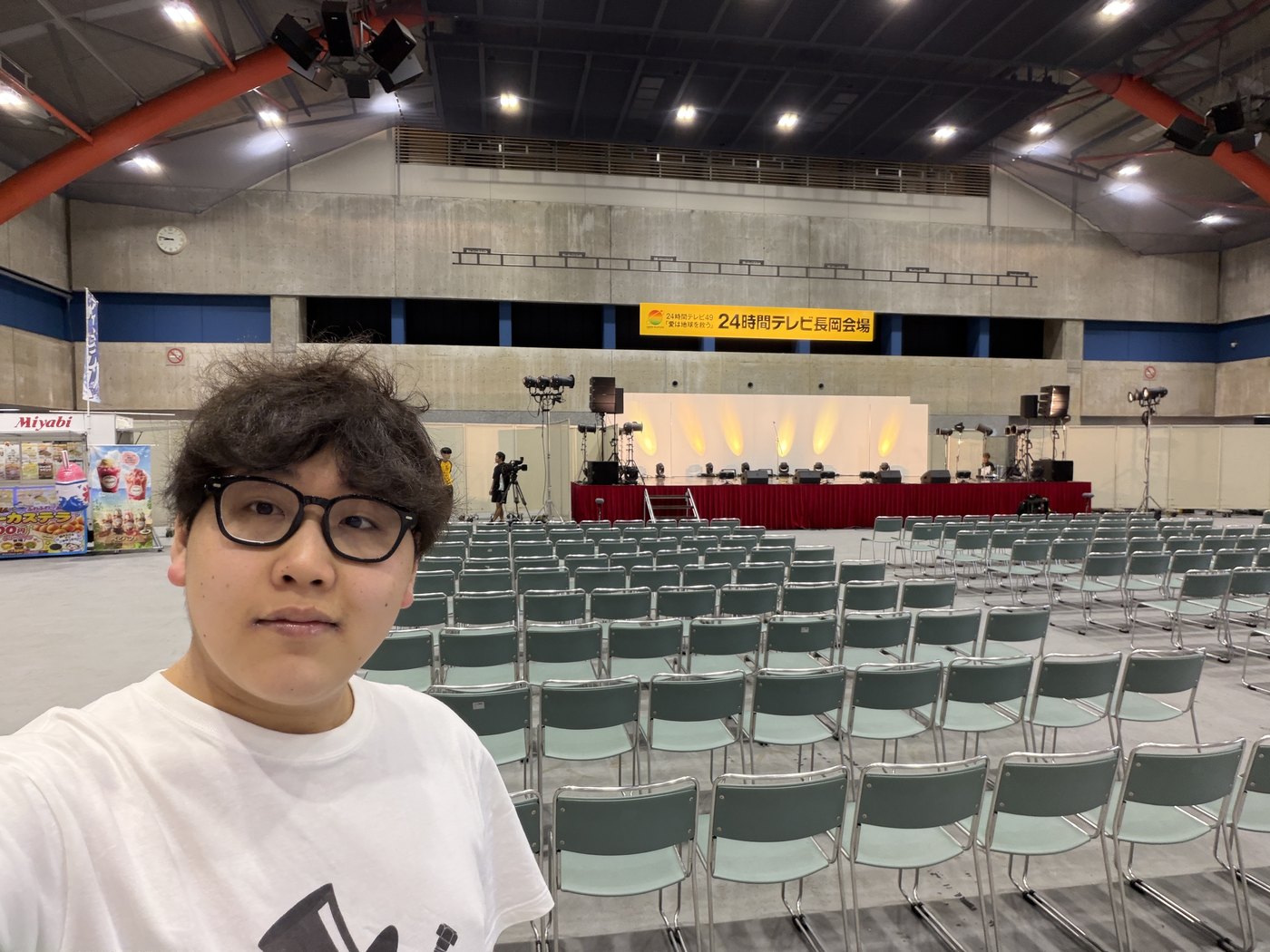 開演前のハイブ長岡。空席が並ぶ客席とステージを背景にしたマジシャンDaiSuke